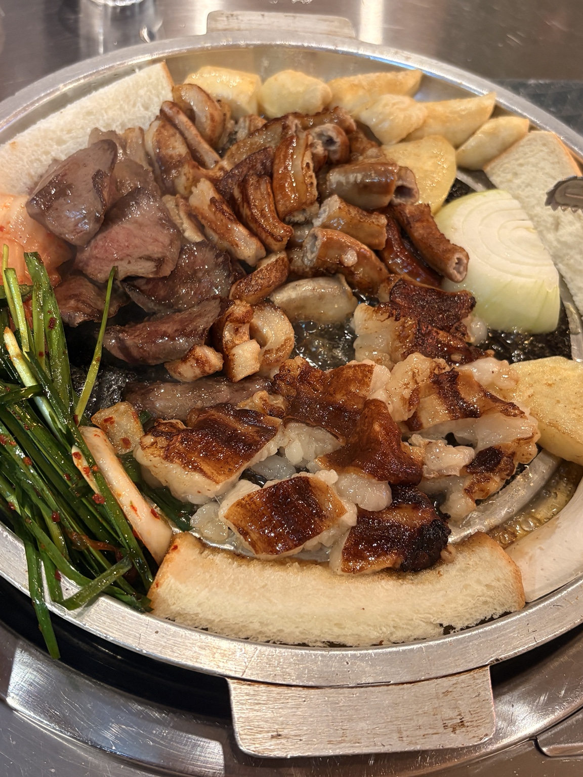 Golden-brown gopchang, daechang and makchang on a grill at Mangopjip Songdo